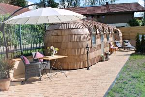 een patio met een parasol en een tafel en stoelen bij Igluhut Tiny House Bayerischer Wald in Zachenberg