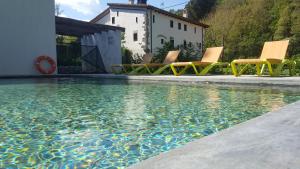 un grupo de sillas sentadas junto a una piscina en B&B La Rectoria de Sant Miquel de Pineda, en Sant Feliu de Pallerols