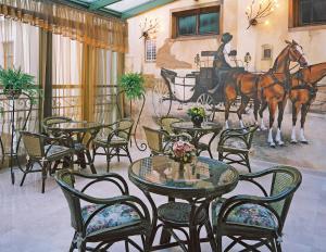 restauracja ze stołami i krzesłami oraz obrazem przedstawiającym konia w obiekcie Hotel Wawel w Krakowie