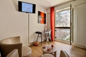 a living room with a tv and a table and a window at Assia & Nathalie - Luxury B&B MARAIS in Paris