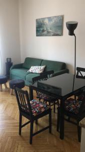 uma sala de estar com um sofá, uma mesa e cadeiras em Casa Dede em Sanremo