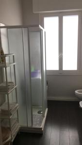 uma casa de banho com uma cabina de duche em vidro e uma janela em Casa Dede em Sanremo