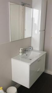 Un baño blanco con lavabo y espejo. en Casa Dede, en San Remo