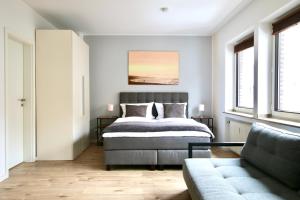 um quarto com uma cama e um sofá em Arthouse Apartments im Pantaleonsviertel em Colônia