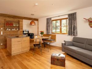 a living room with a couch and a table at Brunnwirt ESSEN & WOHNEN in Fuschl am See
