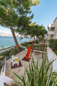 een speeltuin met een glijbaan en stoelen en de oceaan bij Sutivan Best Apartments in Sutivan