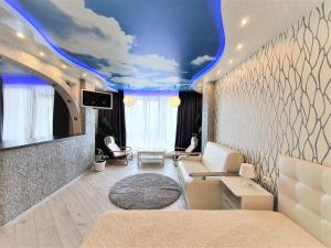 a living room with a blue ceiling with a cloud mural at MEGAPOLIS проспект Революции 9-А-239 in Voronezh