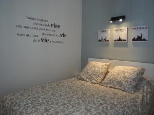 Un dormitorio con una cama con dos almohadas encima. en Le Millotet - Agréable studio à 2 mn Dijon Gare, en Dijon