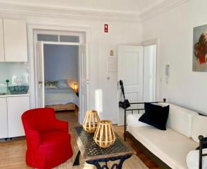 een woonkamer met een bank en een rode stoel bij Old Town Terrace Apartment in Évora +13 foto's