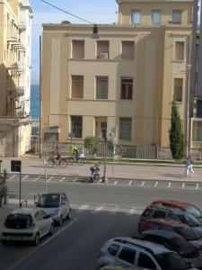eine Straße mit Autos, die vor einem Gebäude geparkt sind in der Unterkunft Casa Vacanze Helsinore in Sanremo