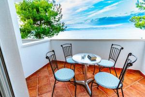 een balkon met een tafel en stoelen en uitzicht op de oceaan bij Sutivan Best Apartments in Sutivan