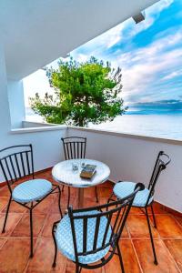 een tafel en stoelen op een balkon met uitzicht op de oceaan bij Sutivan Best Apartments in Sutivan