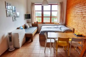 Cihlářka - horský apartmán 103 في تشيرني دول: غرفة صغيرة بسرير وطاولة وكراسي
