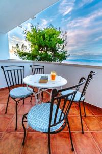 een tafel en stoelen op een balkon met uitzicht op de oceaan bij Sutivan Best Apartments in Sutivan