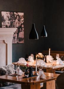 a dining room with wooden tables with candles and black walls at Hotel Lenderstuben in Balzhausen