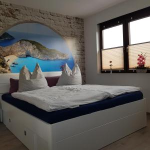 a bedroom with a bed with a painting on the wall at Susi"s Ferienwohnungen in Wermelskirchen