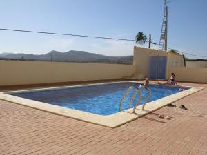 una piscina con 2 personas. en Villa Cristal II 3308 - Resort Choice, en Los Nietos