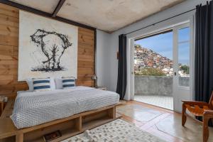 a bedroom with a bed and a large window at Ipanema Hills Loft in Rio de Janeiro