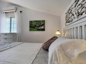 a white bedroom with a bed and a lamp at Villa Perla - Puerto de Mazarron in Puerto de Mazarrón