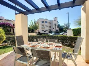 a dining table and chairs on a patio at Roda Golf Resort 4109 - Nicky in San Javier
