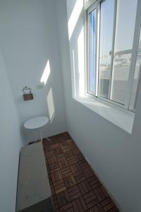 um quarto com uma cadeira e uma janela em Leaf Hostel em Tainan