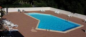 una grande piscina con sedie e un sacco d'acqua di Appt Dolus-d'Oléron, Vert bois 2-3 personnes a Grand-Village-Plage