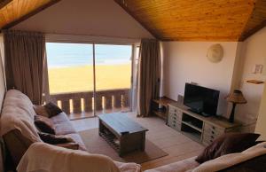 ein Wohnzimmer mit einem Sofa und einem Flachbild-TV in der Unterkunft Seaview at it’s best in Henties Bay