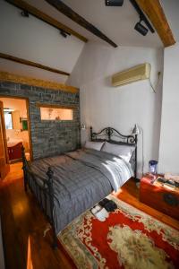 a bedroom with a bed and a brick wall at Fuxishan East Inn in Huairou