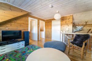 salon z kabiną prysznicową, telewizorem i krzesłem w obiekcie Three-Bedroom Holiday Cottage w mieście Tjørhom