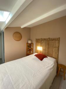 a bedroom with a large white bed and a lamp at Maison de vacance proche de la mer in Les Sables-dʼOlonne