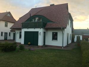 a large white house with a green garage at de lütte Kabuff in Born