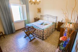 sypialnia z łóżkiem, krzesłem i oknem w obiekcie CASE&COLLINE Pozzo 2 w mieście Montescudaio
