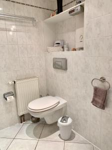 a white bathroom with a toilet and a sink at Ferienwohnung Fürstenwalde Spree in Ketschendorf