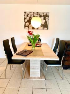 einen Esstisch mit einer Blumenvase darauf in der Unterkunft Ferienwohnung Fürstenwalde Spree in Ketschendorf
