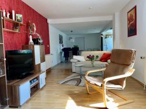 sala de estar con sofá y TV en Ferienwohnung Fürstenwalde Spree, en Ketschendorf