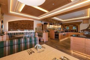 a kitchen and dining room with a table and a counter at Hotel Sporthof Austria in Ramsau am Dachstein