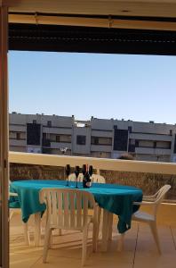 een tafel en stoelen op een balkon met uitzicht op een gebouw bij Studio Naturiste "LIBERTY" Héliopolis K 125 in Cap d'Agde