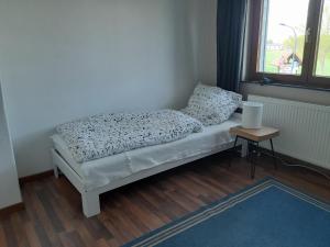 a small bed in a room with a window at Bassener Monteurwohnung in Oyten