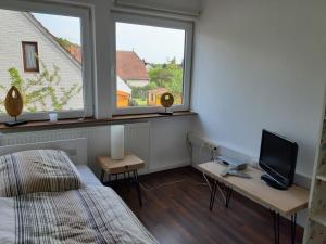 a bedroom with a bed and a desk with a television at Bassener Monteurwohnung in Oyten