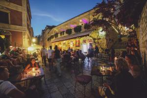 a group of people sitting at tables in a street at night at Heritage Hotel Park Hvar in Hvar