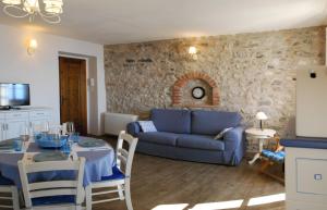 a living room with a blue couch and a table at Rustico Melograno, Il Melo - Rebomaholidays in Tignale