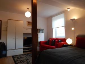 sypialnia z czerwonym łóżkiem i czerwoną kanapą w obiekcie ROKO Apartments w Kownie