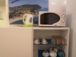 a microwave oven sitting on top of a shelf at A Due Passi Dal Mare B&B in Numana