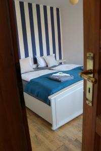 a bed with a blue and white striped headboard at Altstadtcafé und Pension in Havelberg