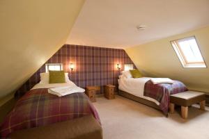 a attic room with two beds and a couch at Balnakeil House in Balnakeil