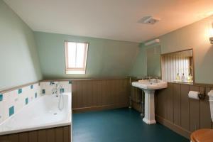 a bathroom with a bath tub and a sink at Balnakeil House in Balnakeil