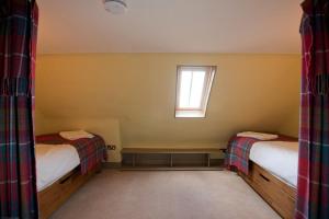 a small room with two beds and a window at Balnakeil House in Balnakeil