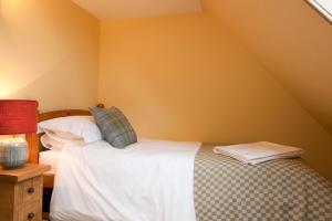a bedroom with a bed with white sheets and pillows at Balnakeil House in Balnakeil