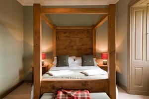 a bedroom with a bed with a wooden headboard at Balnakeil House in Balnakeil
