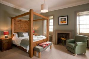 a bedroom with a canopy bed and a chair at Balnakeil House in Balnakeil